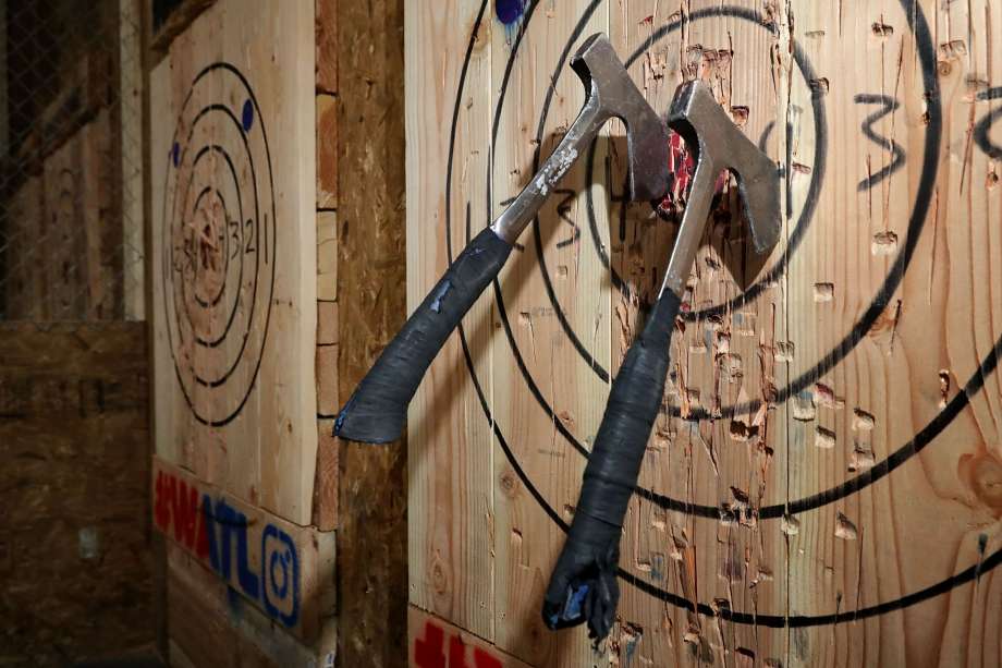 Two axes embedded in a wooden bullseye target at a throwing lane