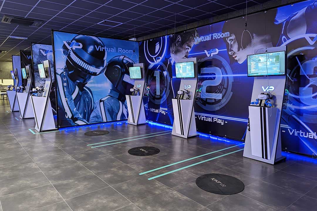 VR arcade with multiple stations, displays, and floor markers